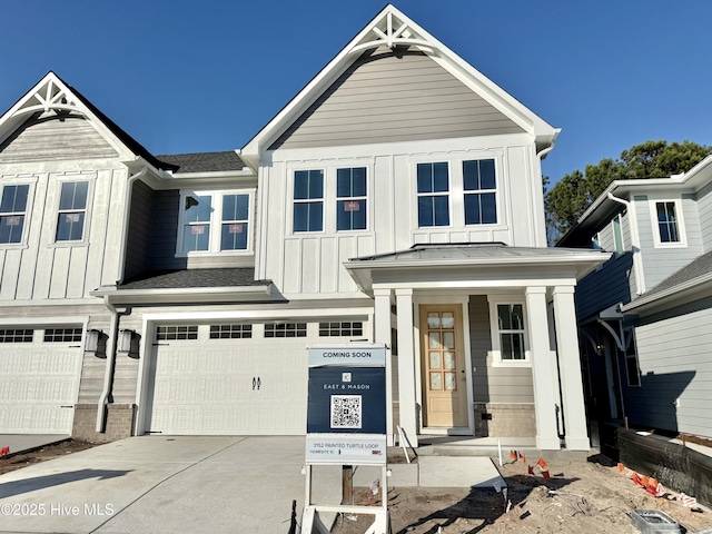 view of front facade with a garage, driveway, board and batten siding, and roof with shingles