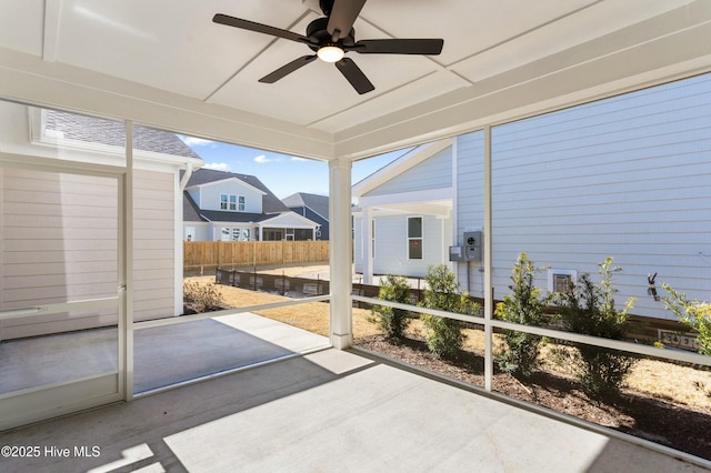 sunroom featuring ceiling fan and a residential view