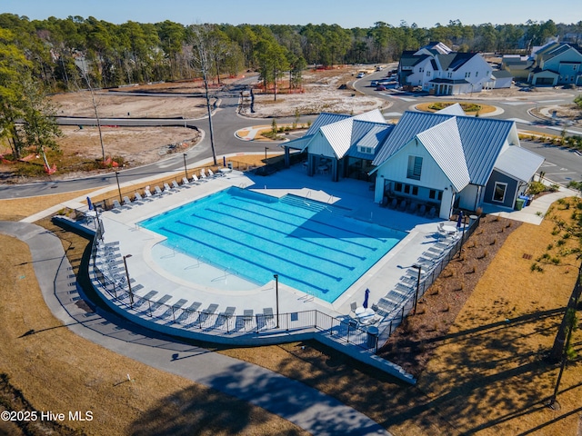 community pool with a patio area and fence