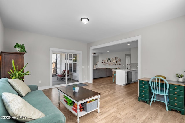 living area featuring light wood finished floors and baseboards