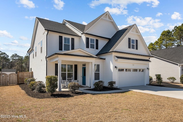 view of front of house featuring a garage, concrete driveway, fence, a porch, and a front yard