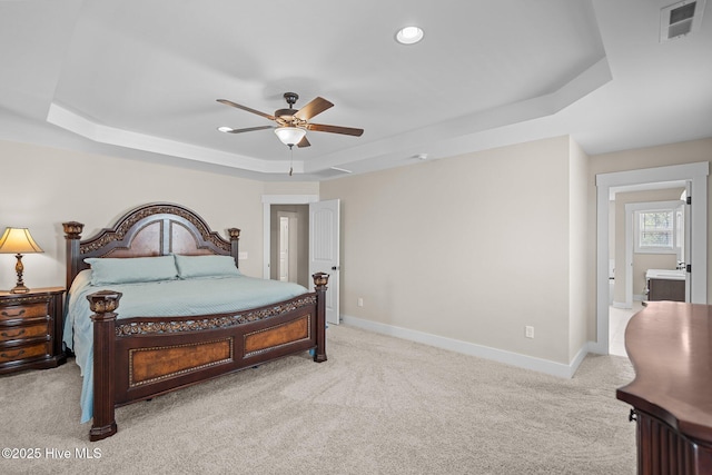 bedroom with carpet flooring, a raised ceiling, visible vents, and baseboards