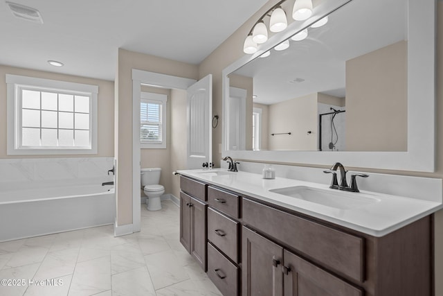 bathroom featuring marble finish floor, walk in shower, a sink, and toilet