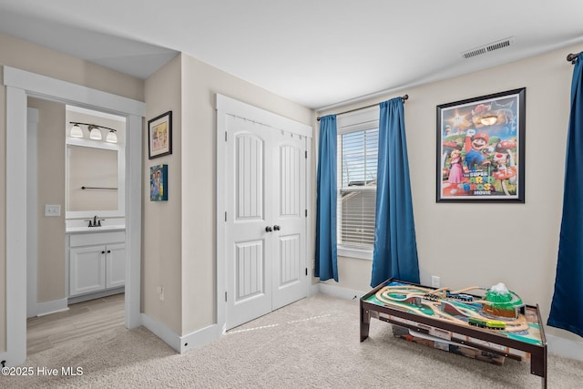 game room featuring light carpet, baseboards, visible vents, and a sink