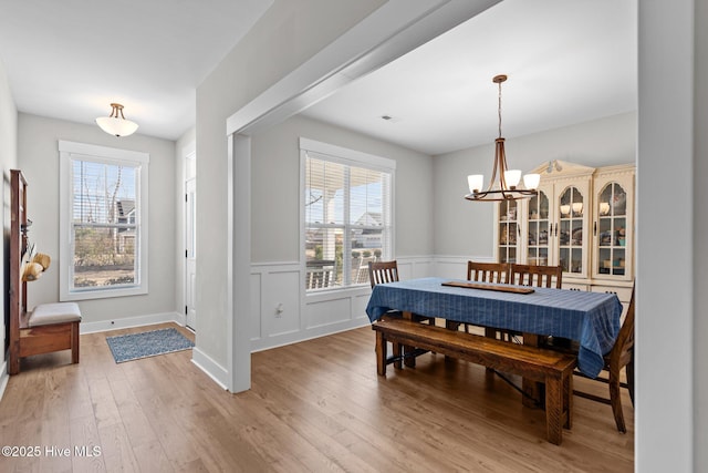 dining area featuring a notable chandelier, light wood-style flooring, and a healthy amount of sunlight