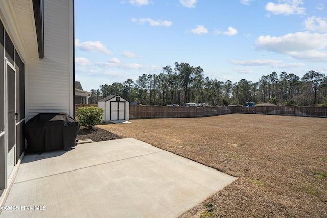 view of yard featuring an outbuilding, a patio, a shed, and a fenced backyard