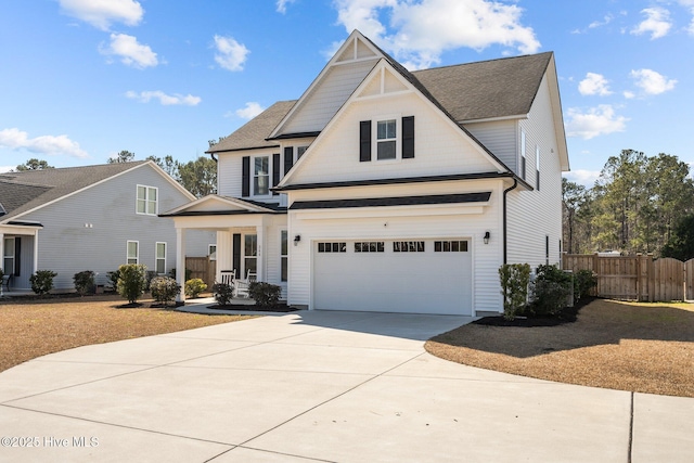 view of front of home with concrete driveway, fence, and an attached garage