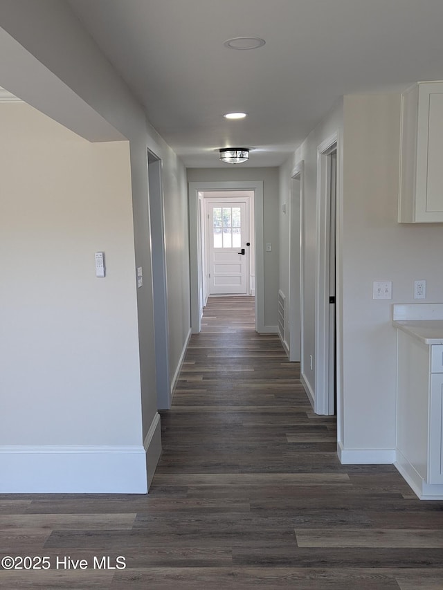 hallway featuring dark wood-style floors and baseboards