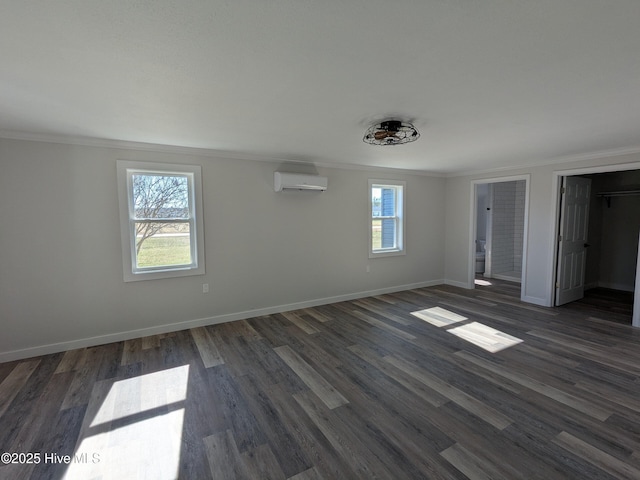 unfurnished bedroom with ornamental molding, baseboards, a wall unit AC, and dark wood-type flooring