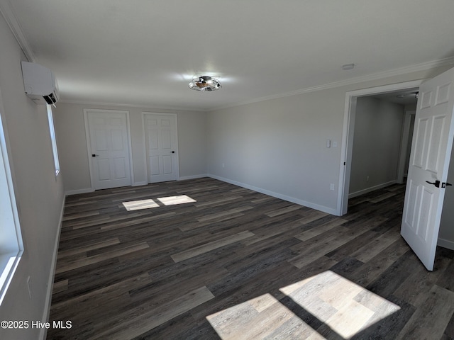 unfurnished bedroom with ornamental molding, an AC wall unit, dark wood finished floors, and baseboards