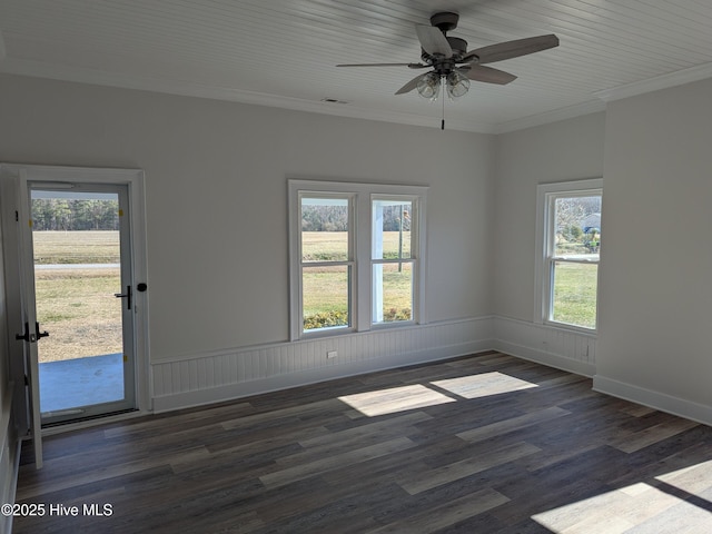 empty room featuring wainscoting, crown molding, and wood finished floors