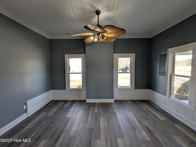 spare room with crown molding, a healthy amount of sunlight, and dark wood finished floors