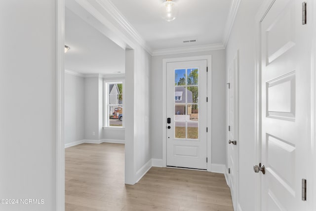 foyer with visible vents, light wood-style flooring, baseboards, and ornamental molding