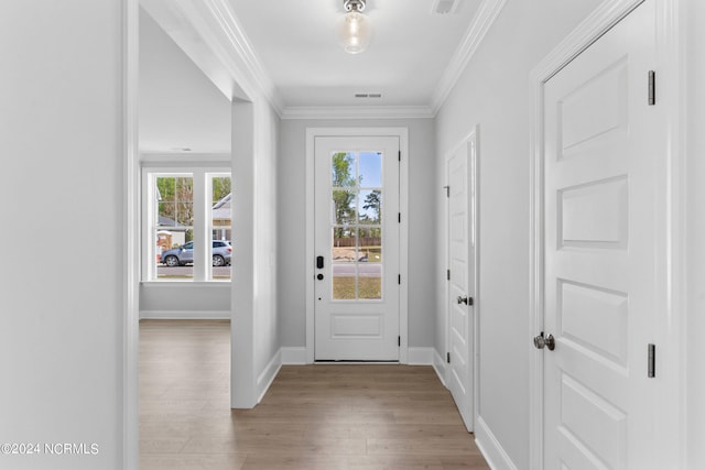 entryway featuring visible vents, baseboards, light wood-style floors, and crown molding