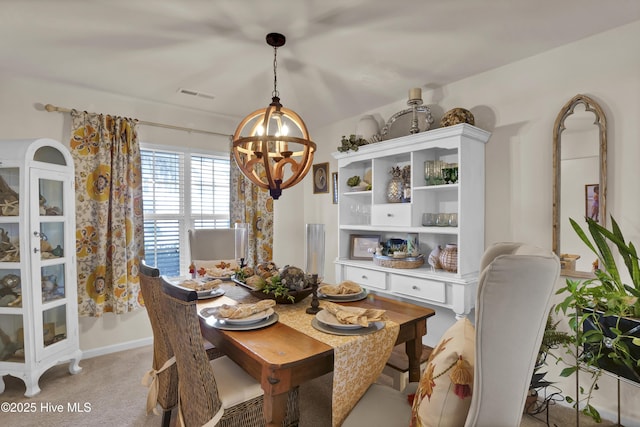 dining room featuring a chandelier, visible vents, and light colored carpet