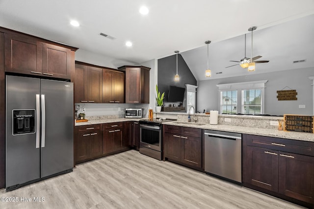 kitchen with stainless steel appliances, a sink, visible vents, dark brown cabinets, and light stone countertops