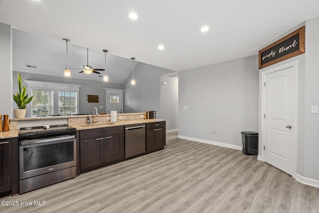 kitchen with light stone counters, light wood-style flooring, appliances with stainless steel finishes, a sink, and dark brown cabinets