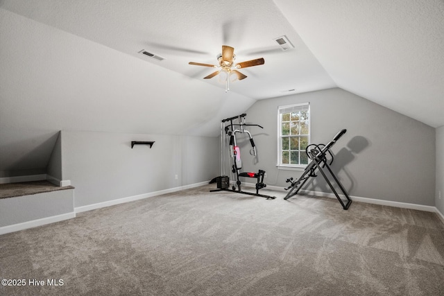 exercise area with carpet, lofted ceiling, visible vents, a textured ceiling, and baseboards