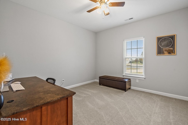 office featuring light colored carpet, ceiling fan, visible vents, and baseboards