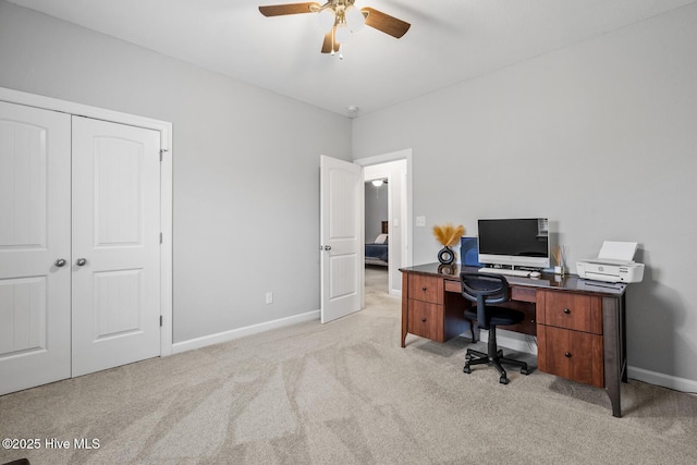 office area featuring ceiling fan, baseboards, and light colored carpet