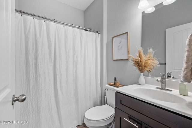 bathroom with a shower with shower curtain, vanity, and toilet