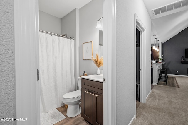 full bath featuring lofted ceiling, visible vents, toilet, vanity, and baseboards