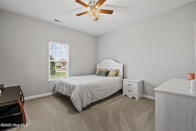 bedroom with light carpet, ceiling fan, visible vents, and baseboards