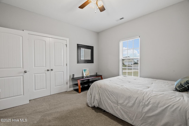 bedroom with a ceiling fan, carpet, visible vents, and a closet