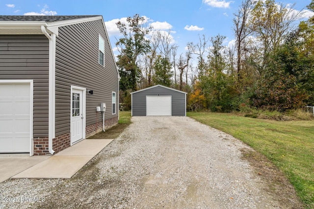 view of home's exterior featuring a yard, an outdoor structure, gravel driveway, and a detached garage