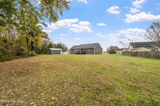 view of yard with an outbuilding, fence, and a storage unit