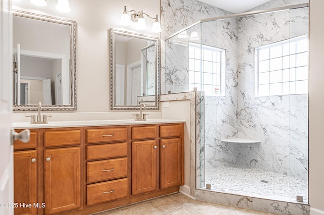 bathroom with double vanity, a sink, a marble finish shower, and tile patterned flooring