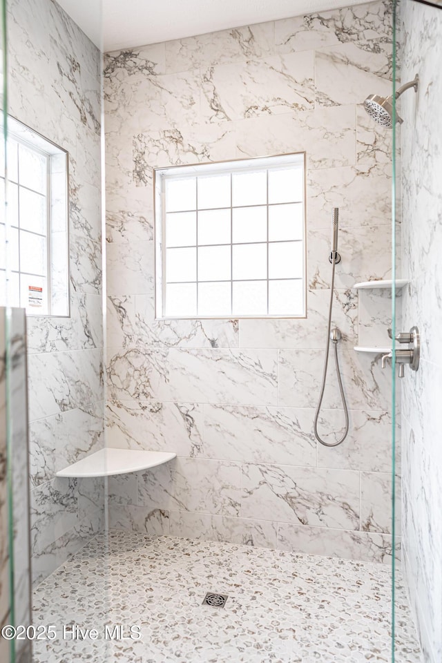 bathroom with a marble finish shower
