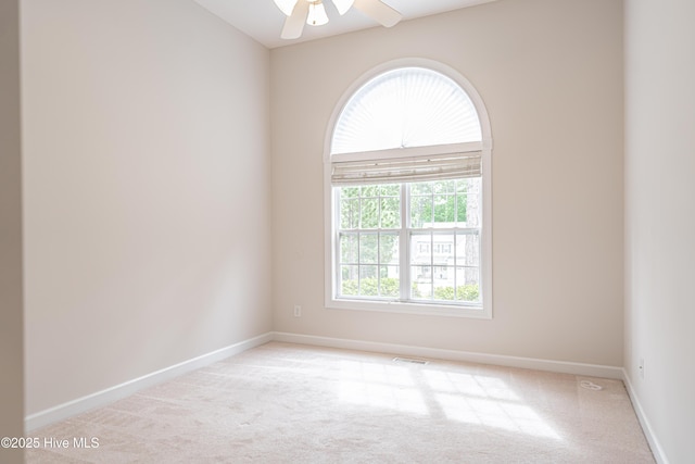 unfurnished room with carpet floors, a ceiling fan, baseboards, and visible vents