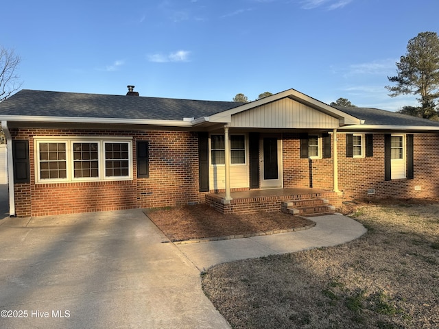 single story home with covered porch, brick siding, crawl space, and roof with shingles