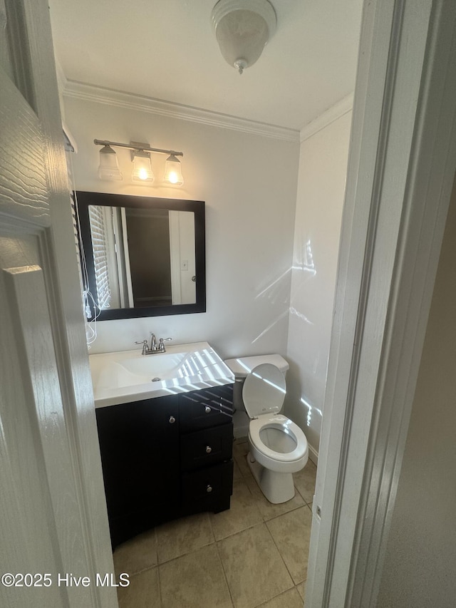 half bath featuring tile patterned flooring, crown molding, vanity, and toilet