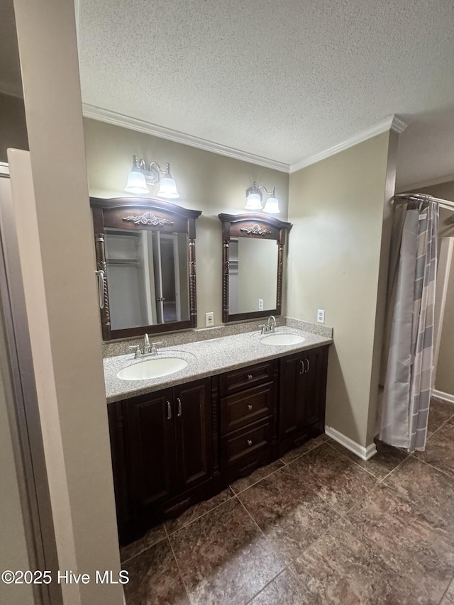 full bathroom with a textured ceiling, double vanity, a sink, and crown molding