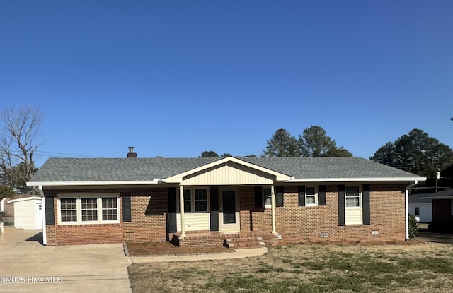 ranch-style house featuring a shingled roof, a porch, and brick siding