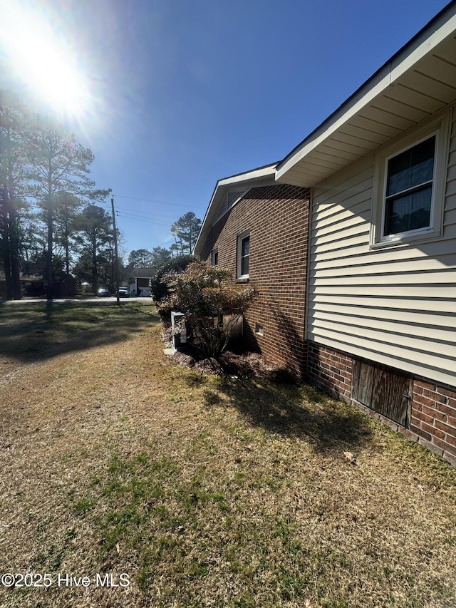 view of side of property featuring crawl space and brick siding