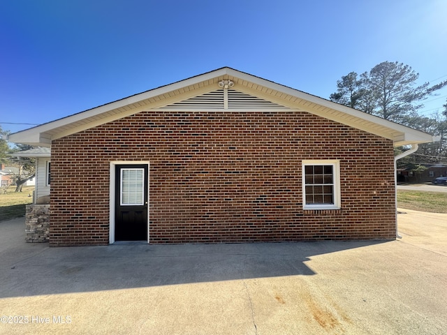 view of side of property featuring brick siding