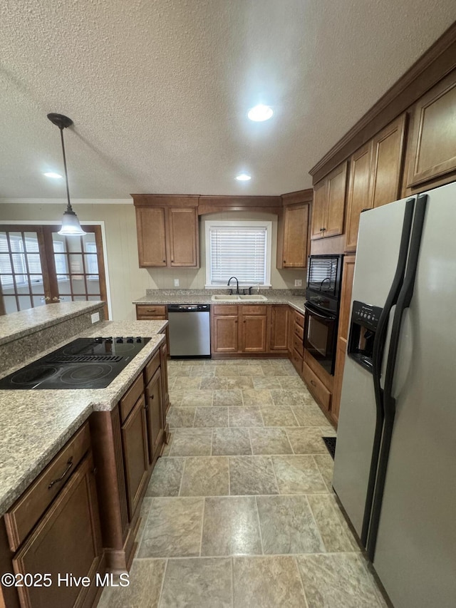 kitchen featuring a healthy amount of sunlight, black appliances, crown molding, and hanging light fixtures