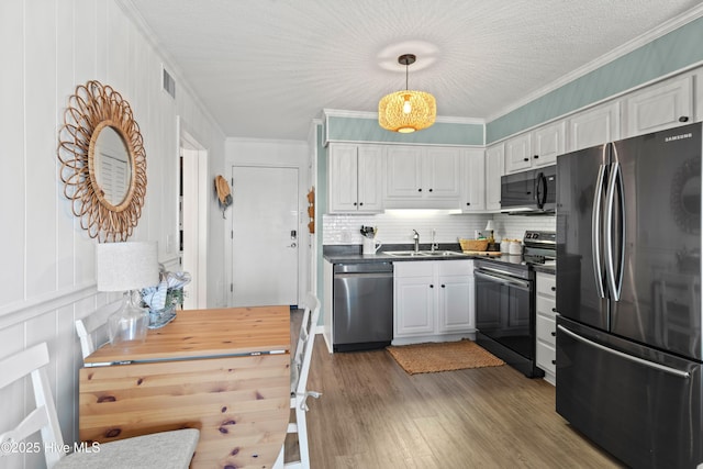 kitchen with electric stove, freestanding refrigerator, crown molding, stainless steel dishwasher, and a sink