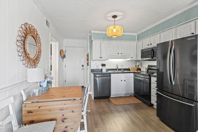 kitchen with range with electric stovetop, crown molding, stainless steel dishwasher, a sink, and freestanding refrigerator