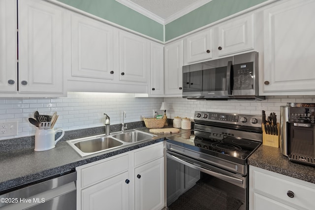 kitchen featuring white cabinets, decorative backsplash, ornamental molding, stainless steel appliances, and a sink