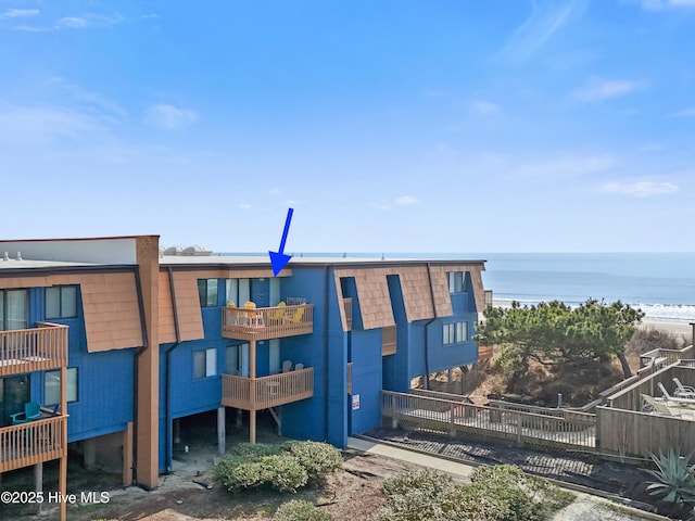 view of building exterior with a water view and fence