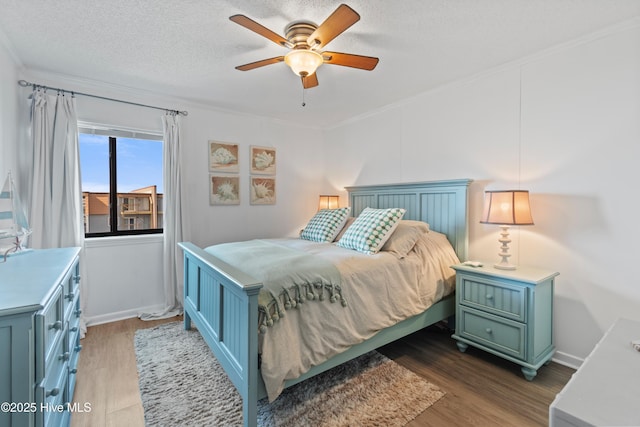 bedroom with crown molding, a ceiling fan, a textured ceiling, and wood finished floors