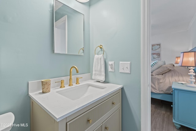 bathroom with ensuite bathroom, wood finished floors, toilet, and vanity