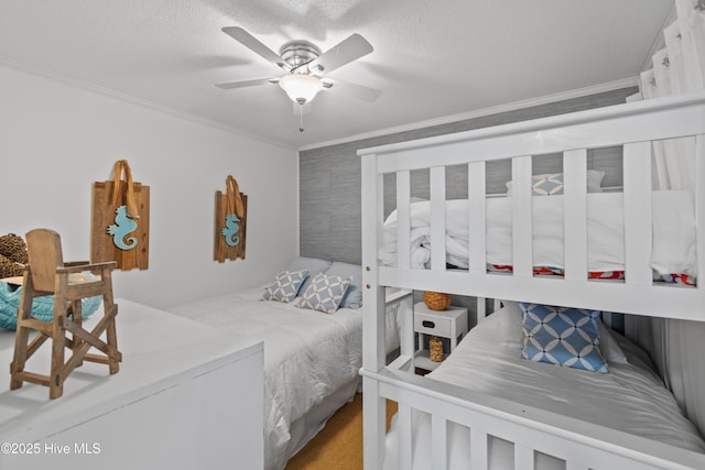 bedroom with a ceiling fan, ornamental molding, and a textured ceiling