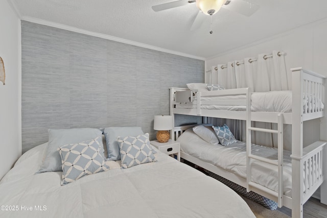 bedroom featuring ornamental molding, a textured ceiling, and a ceiling fan