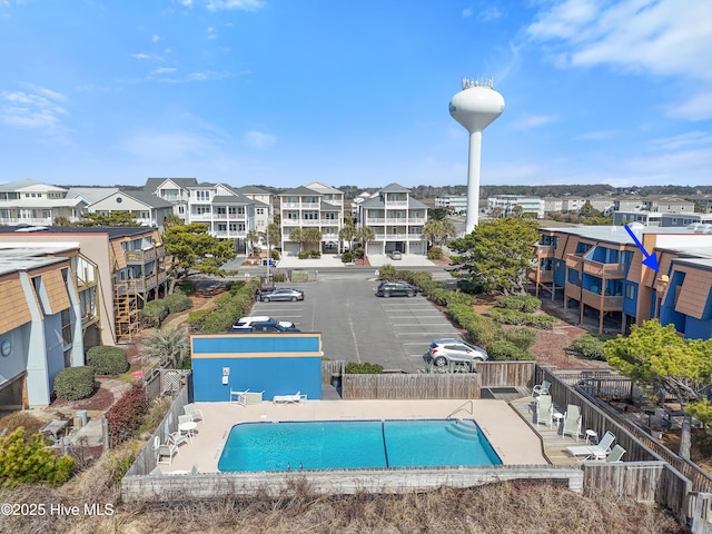 community pool with fence and a residential view