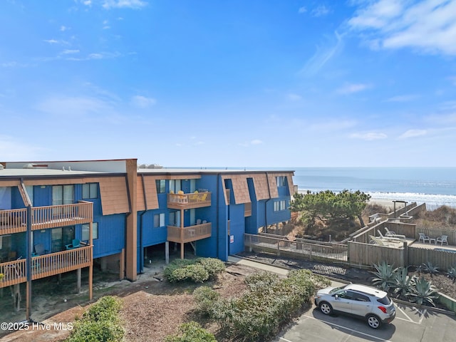 view of building exterior with a water view and uncovered parking